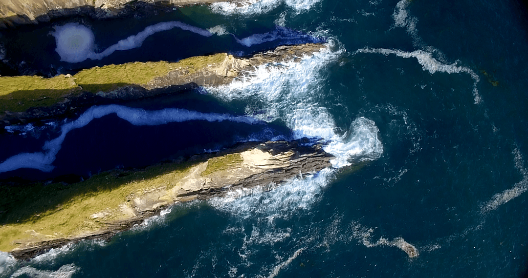 Aerial View Over Rocky Sea Coastline with Transparent Waves