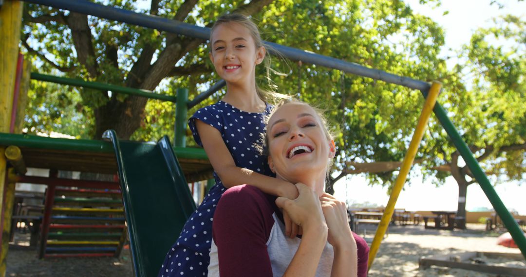 Mother and Daughter Smiling on Playground in Sunny Weather - Free Images, Stock Photos and Pictures on Pikwizard.com