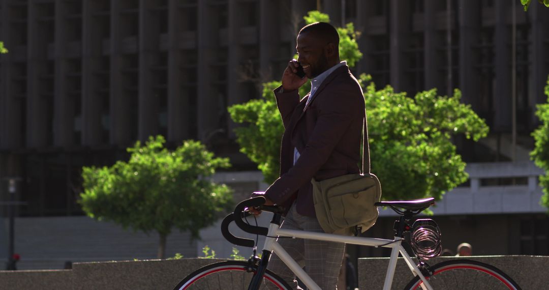 Professional Man on Smartphone Walking with Bicycle in City