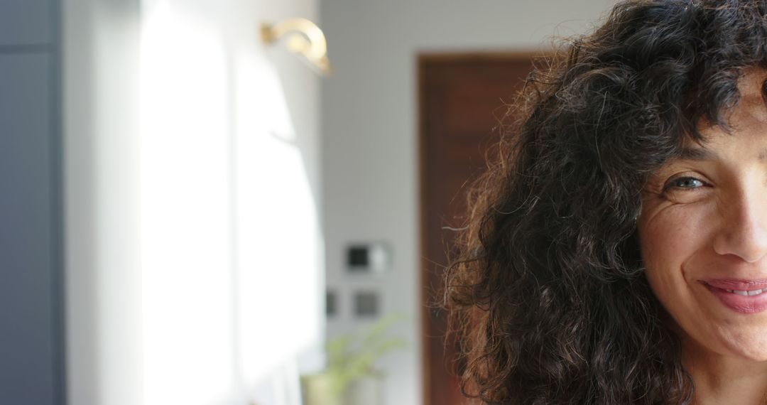 Close-up of Woman Smiling with Curly Hair and Sunlight - Free Images, Stock Photos and Pictures on Pikwizard.com