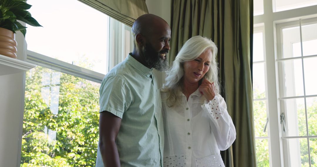 Smiling Multiracial Couple Sharing Moment at Home Near Window