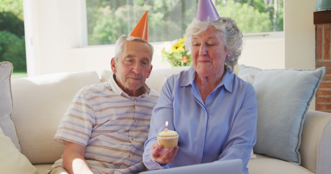 Senior Couple Celebrating Birthday with Cupcake and Candle - Free Images, Stock Photos and Pictures on Pikwizard.com