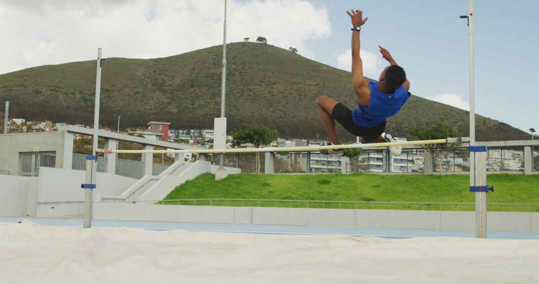 Athlete Performing High Jump with Mountain in Background - Free Images, Stock Photos and Pictures on Pikwizard.com