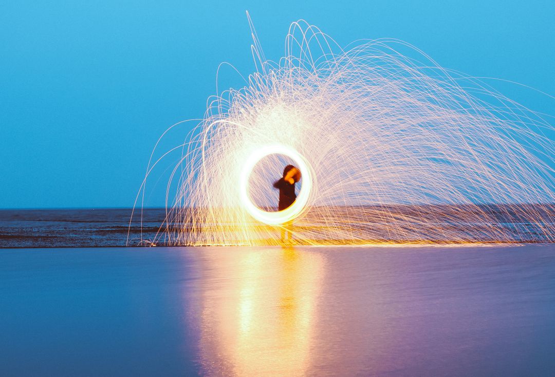 Person Creating Light Trails on Beach at Night - Free Images, Stock Photos and Pictures on Pikwizard.com