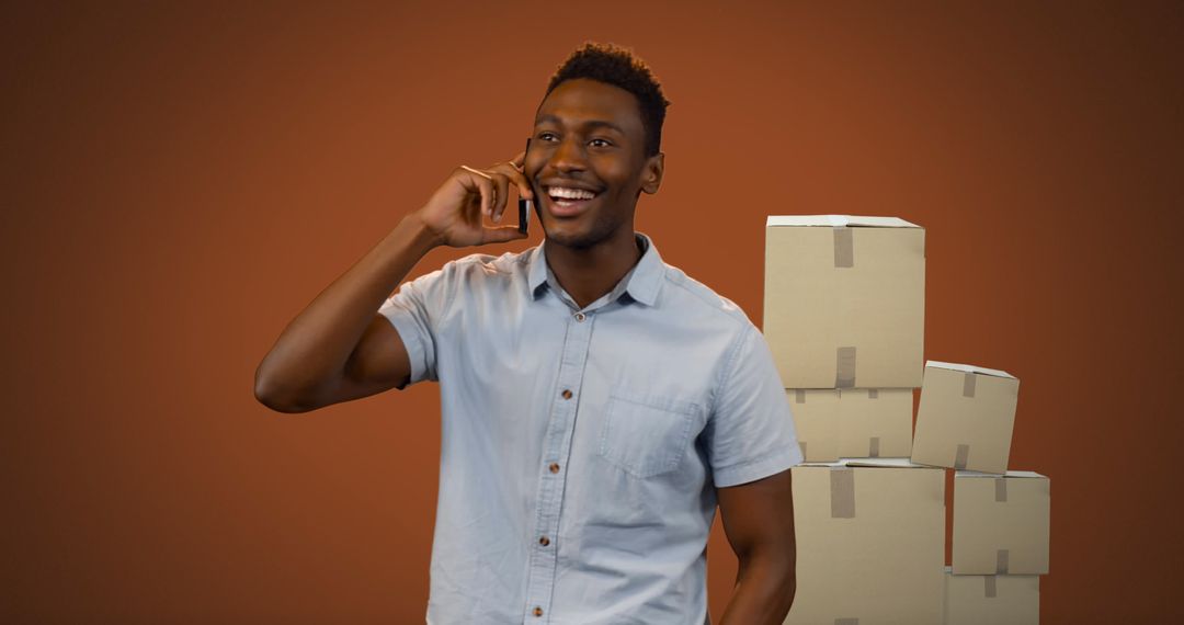 Smiling Man Talking on Smartphone with Shipping Boxes