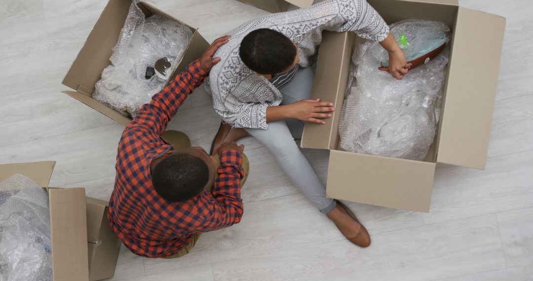 Couple Unpacking Boxes and Organizing Items at New Home