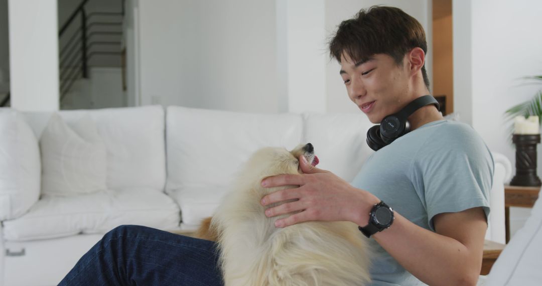 Young Man Relaxing with Fluffy Dog in Living Room - Free Images, Stock Photos and Pictures on Pikwizard.com