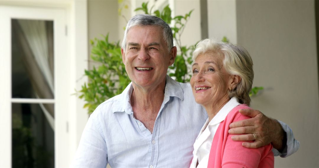 Cheerful Elderly Couple Embracing Outdoors by House - Free Images, Stock Photos and Pictures on Pikwizard.com