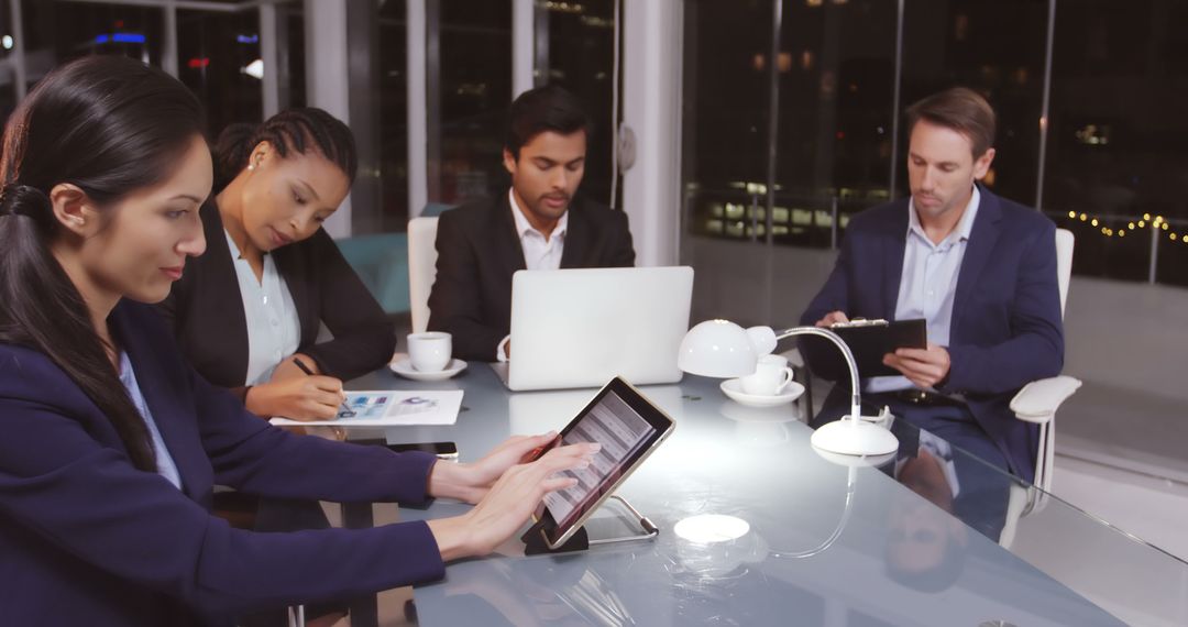 Diverse Professionals in Night Meeting Collaborate on Tasks