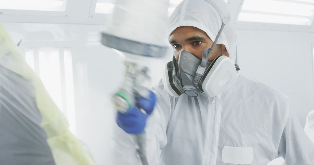 Industrial Worker Wearing Protective Gear Spraying Paint in Cleanroom - Free Images, Stock Photos and Pictures on Pikwizard.com