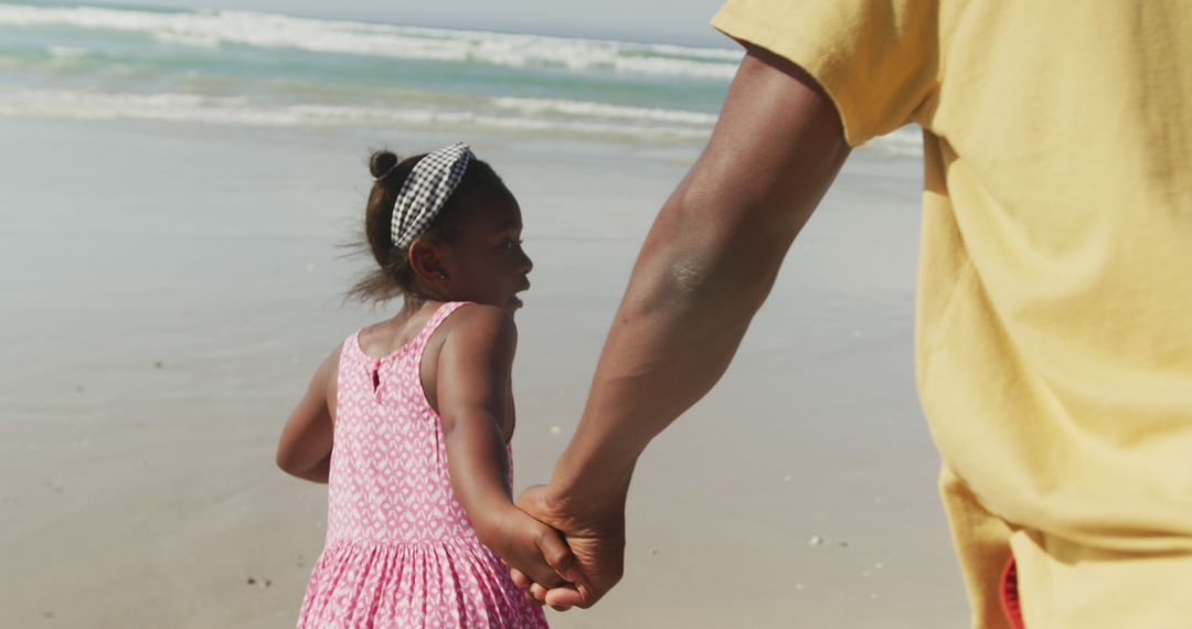 African american father and daughter holding hands running on the beach - Free Images, Stock Photos and Pictures on Pikwizard.com