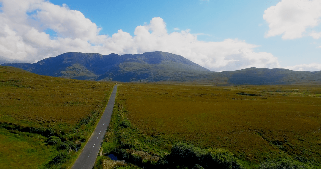 Tranquil Transparent Road Amidst Lush Landscape and Majestic Mountains