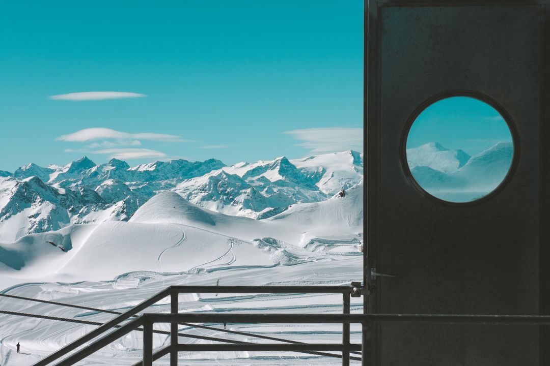 Scenic Snow-Capped Mountains Through Circular Window