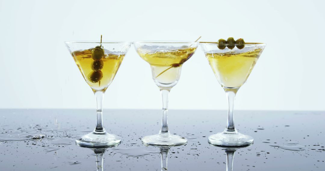 Three Martini Glasses with Olives on Reflective Surface - Free Images, Stock Photos and Pictures on Pikwizard.com