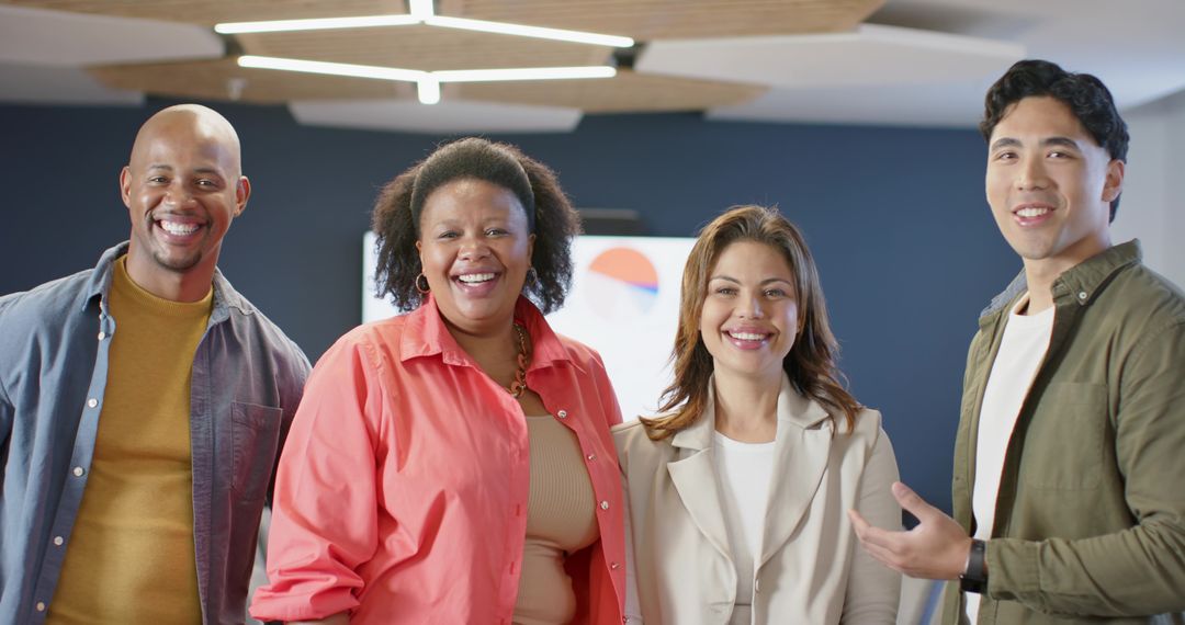 Smiling diverse team collaborating in modern office with presentation screen and charts