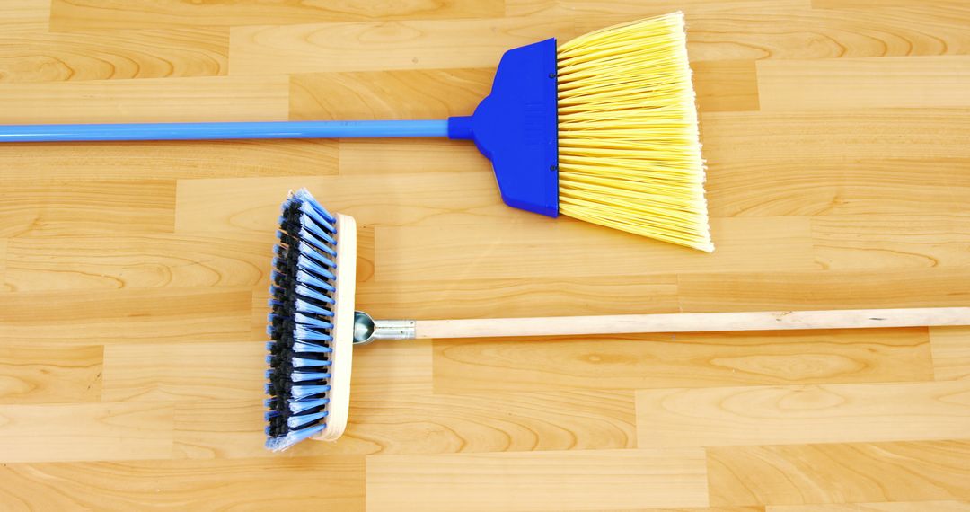 Two brooms on wooden floor representing cleaning tools - Free Images, Stock Photos and Pictures on Pikwizard.com