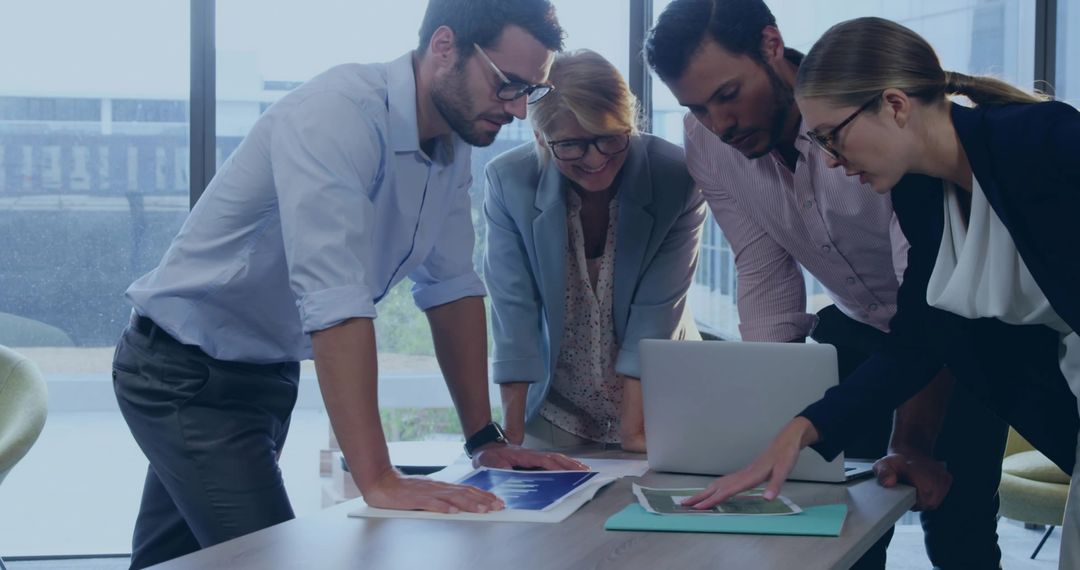 Multigenerational Business Team Collaborating at Table, Reviewing Strategy Plans and Analytics
