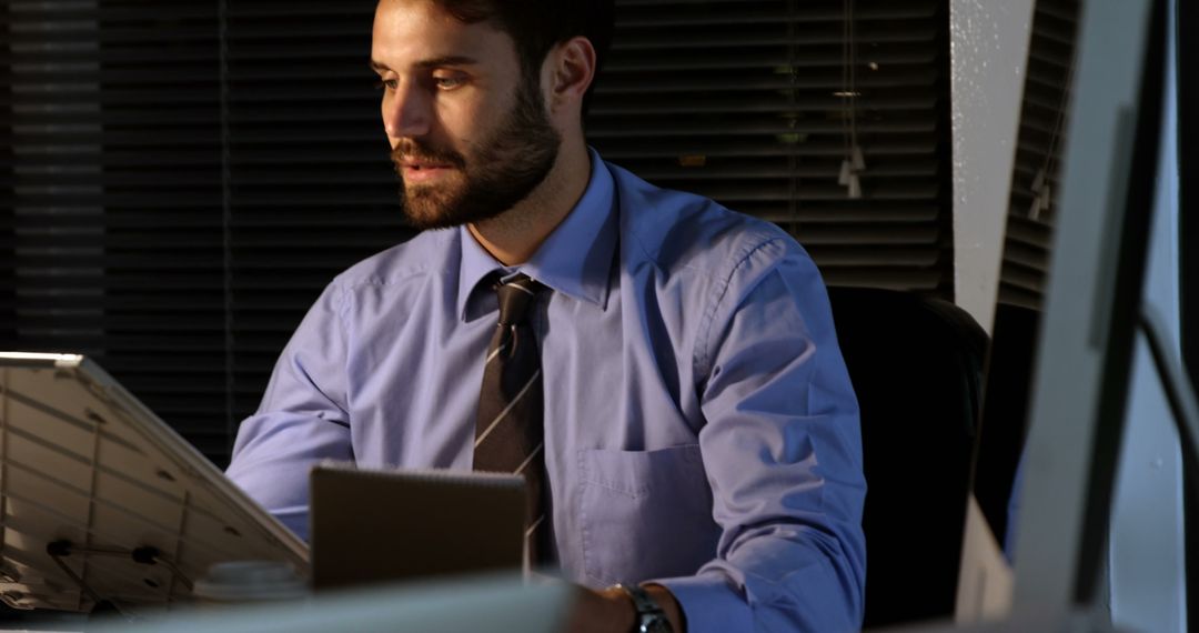 Businessman Working Late at Office Desk - Free Images, Stock Photos and Pictures on Pikwizard.com