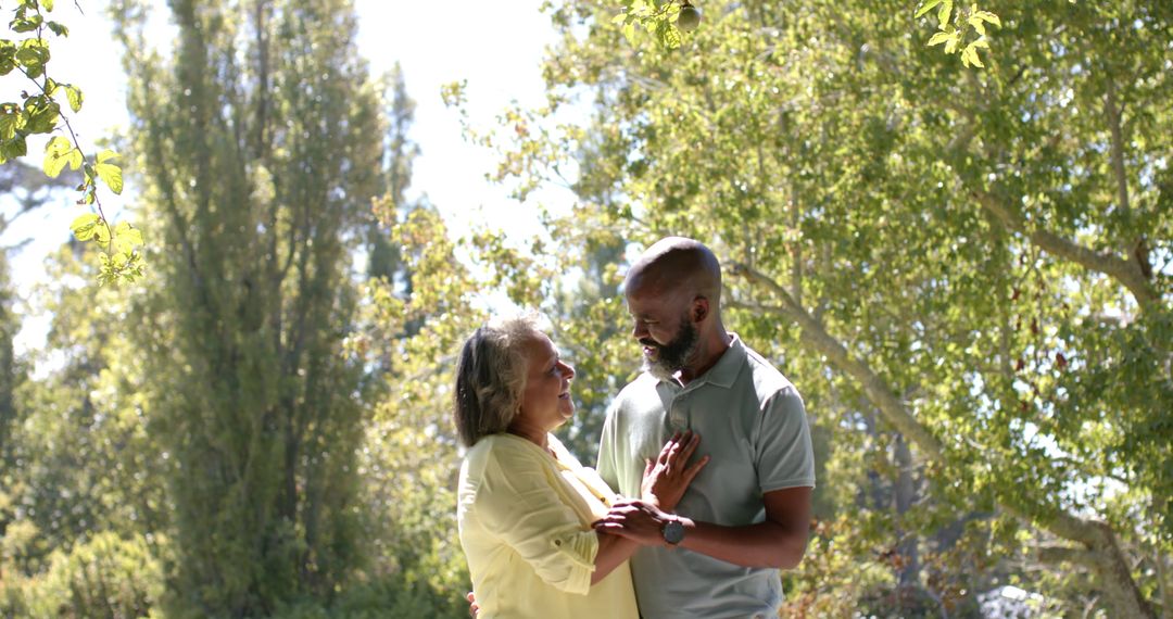 Smiling Senior Couple Enjoying Sunny Day in Park Surrounded by Nature