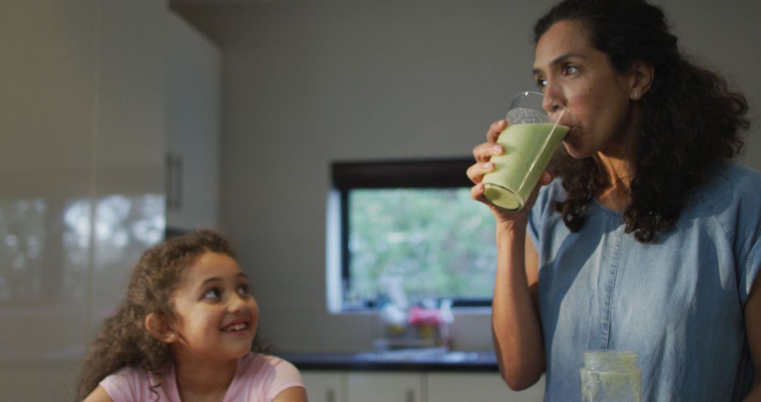 Mother and Daughter in Kitchen Drinking Healthy Green Smoothies - Free Images, Stock Photos and Pictures on Pikwizard.com