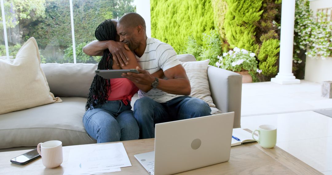 Couple Embracing While Managing Finances At Home
