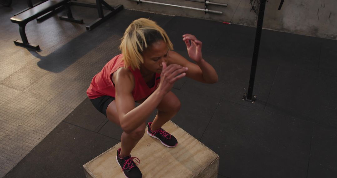 Determined Athlete Performing Box Squat in Gym
