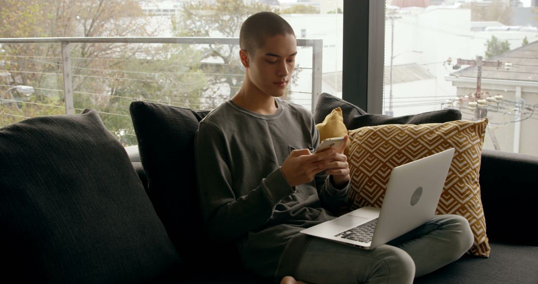 Young person sitting on couch with laptop and ice cream - Free Images, Stock Photos and Pictures on Pikwizard.com