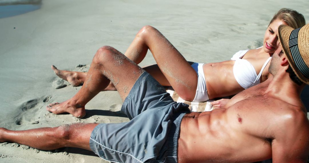 Happy couple lying on beach and interacting with each other on a sunny day 4k - Free Images, Stock Photos and Pictures on Pikwizard.com