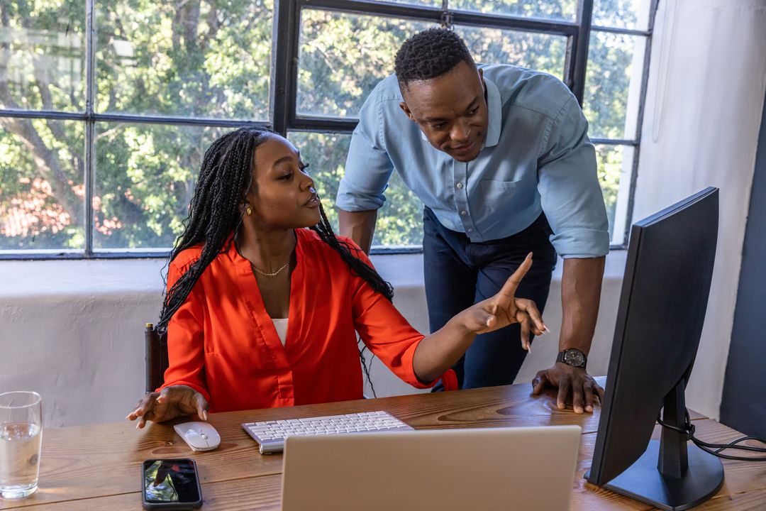 Coworkers Discussing Project at Office Desk for Team Collaboration