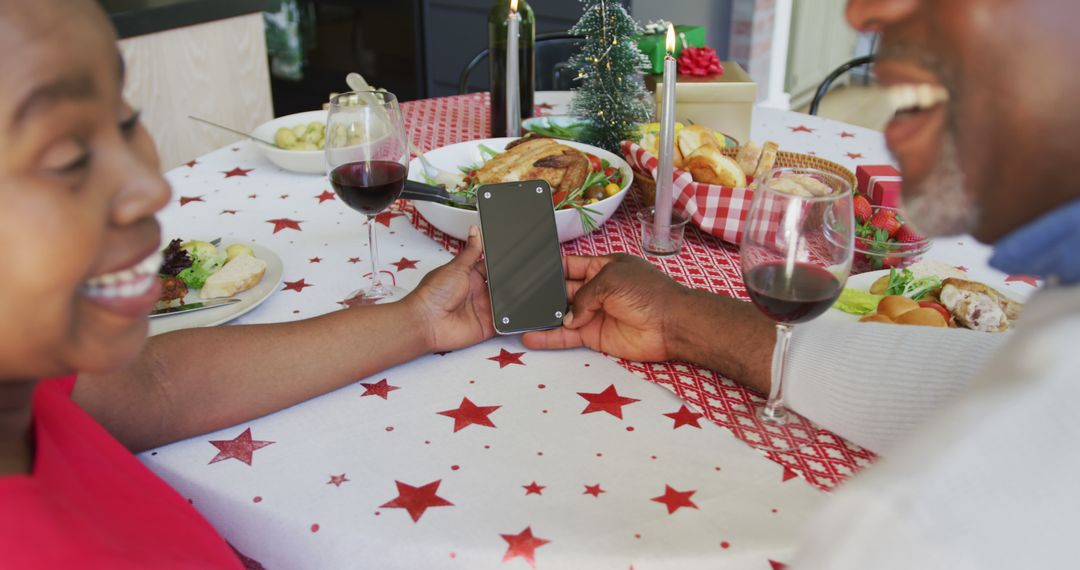 Senior Couple Sharing Smartphone Moment at Holiday Dinner - Free Images, Stock Photos and Pictures on Pikwizard.com