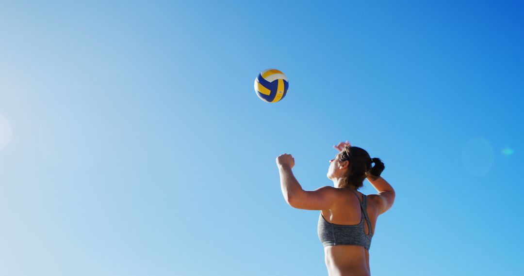 Back View of Woman Playing Beach Volleyball on Sunny Day - Free Images, Stock Photos and Pictures on Pikwizard.com