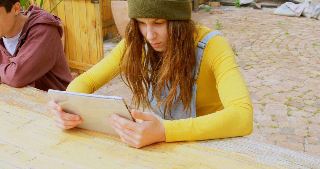 Focused Young Woman Studying on Tablet Outdoors - Free Images, Stock Photos and Pictures on Pikwizard.com