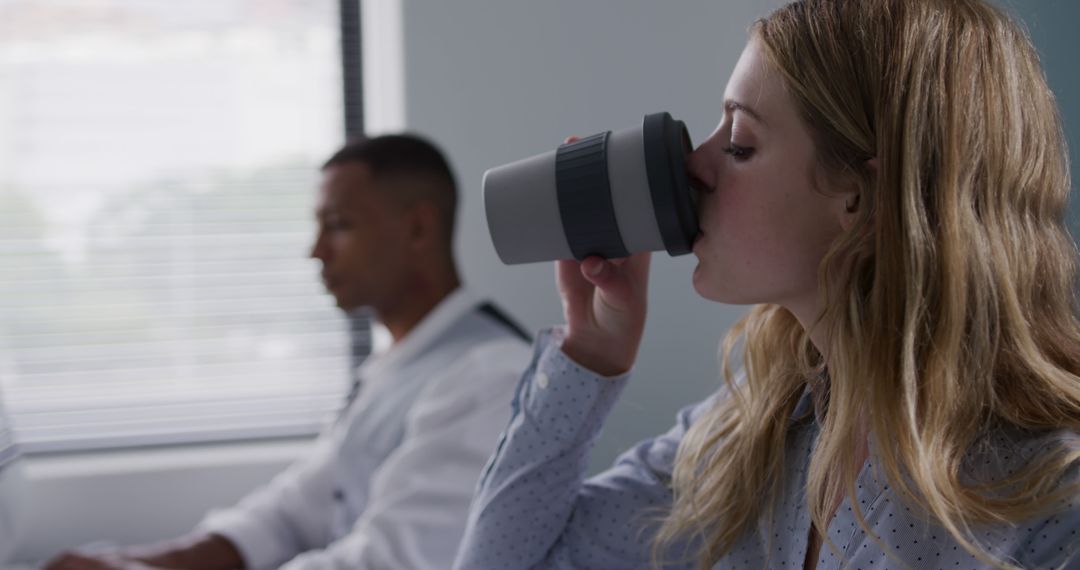 Young Woman Drinking Coffee in Office During Meeting - Free Images, Stock Photos and Pictures on Pikwizard.com