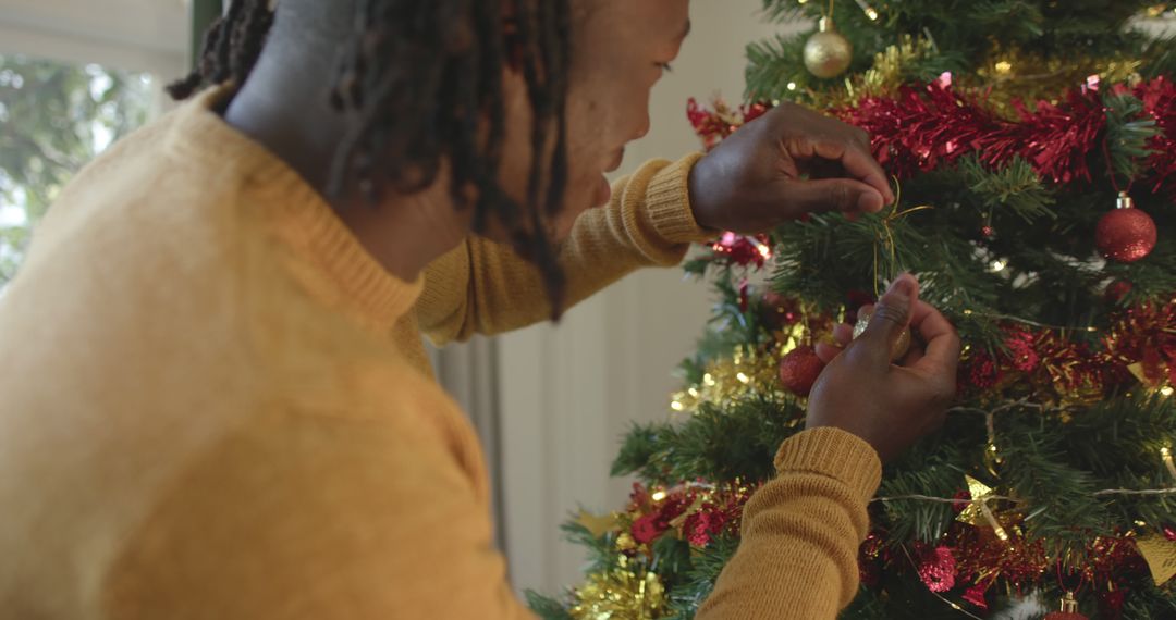 Man Decorating Christmas Tree with Ornaments and Tinsel - Free Images, Stock Photos and Pictures on Pikwizard.com