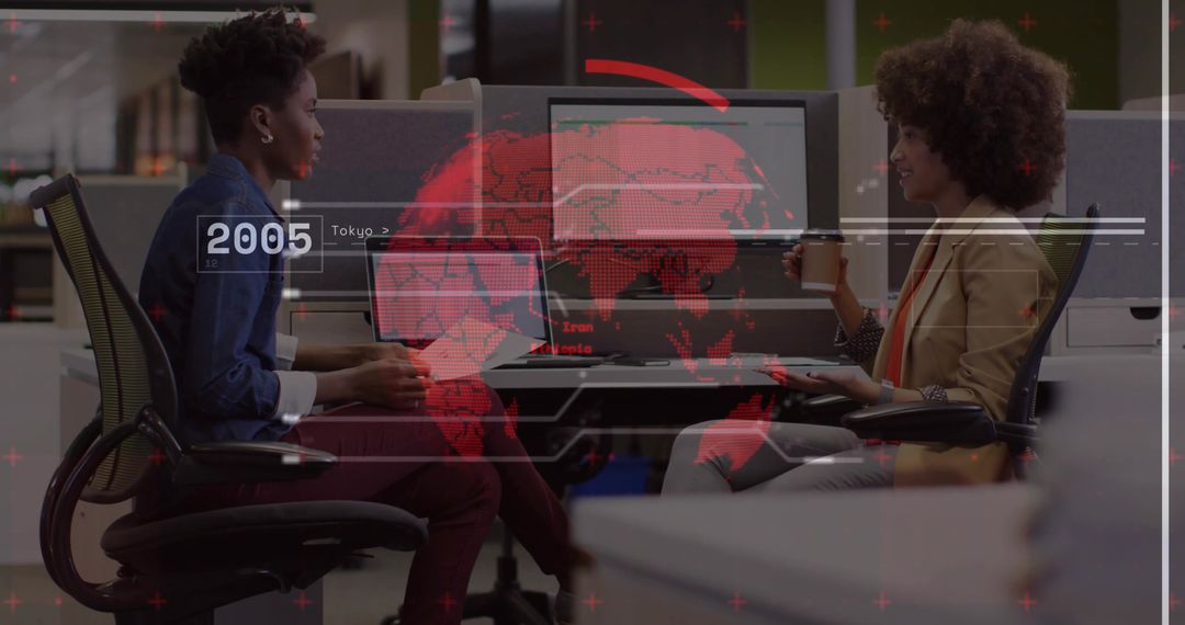 Colleagues collaborating over laptop and coffee with red global data overlay in modern open office