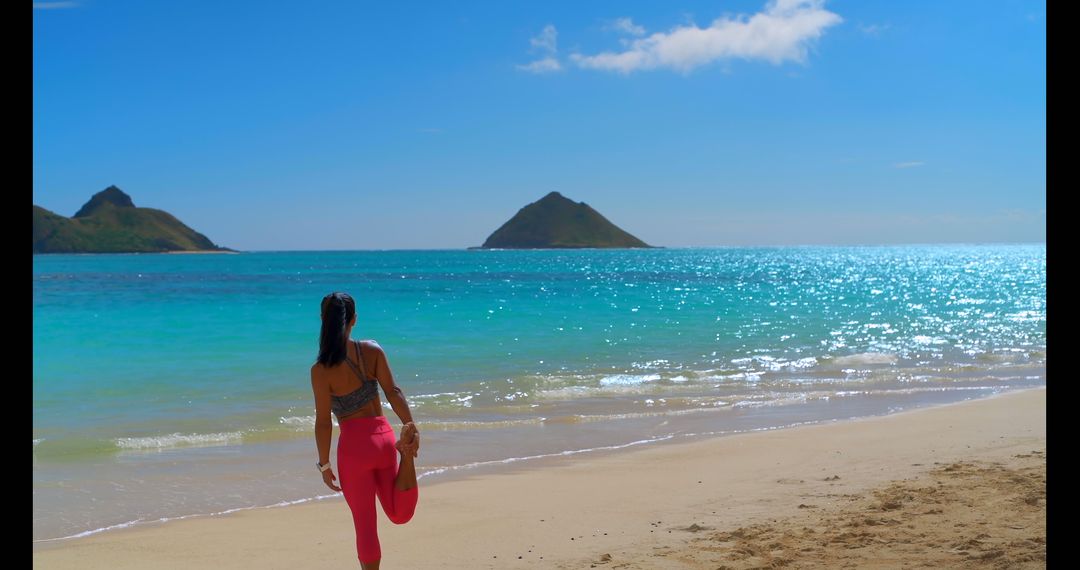 Woman Stretching on Beach Shore Under Blue Sky with Scenic Islands - Free Images, Stock Photos and Pictures on Pikwizard.com