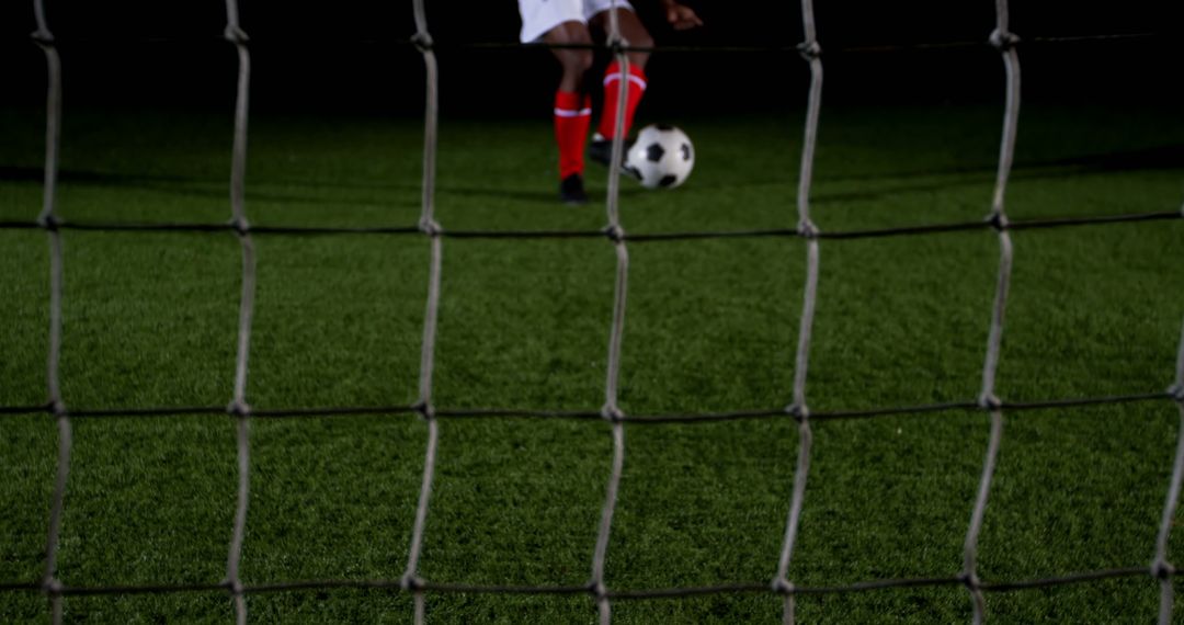 Soccer Player Striking Ball on Green Field at Night - Free Images, Stock Photos and Pictures on Pikwizard.com