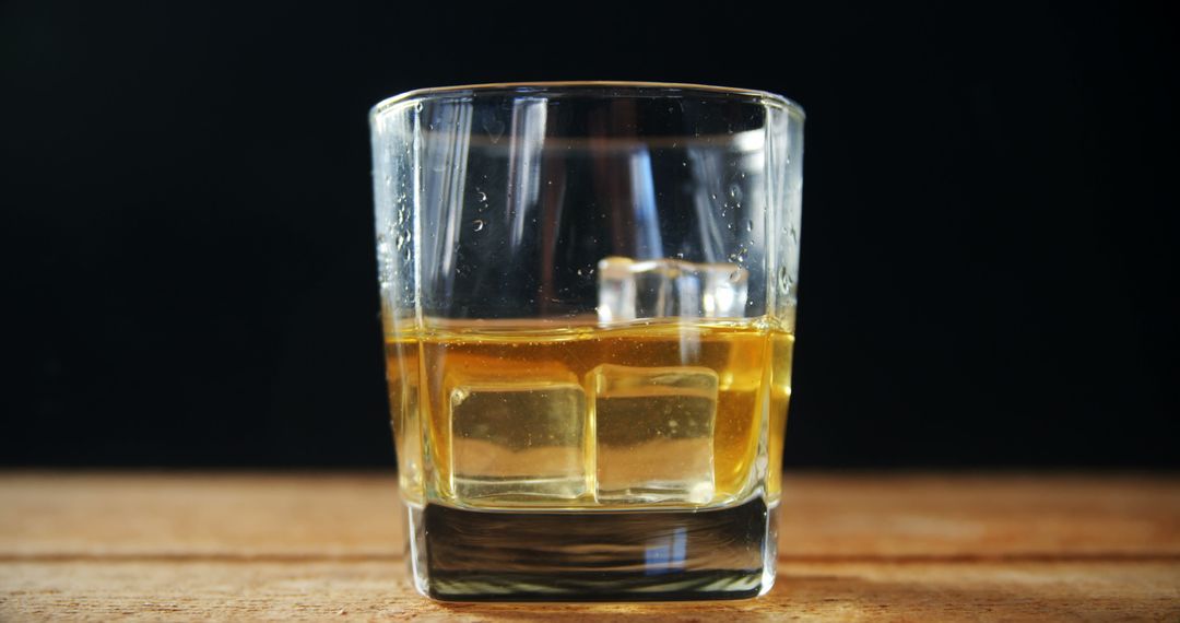 Close-Up of Whiskey Glass with Ice Cubes Splashing Inside