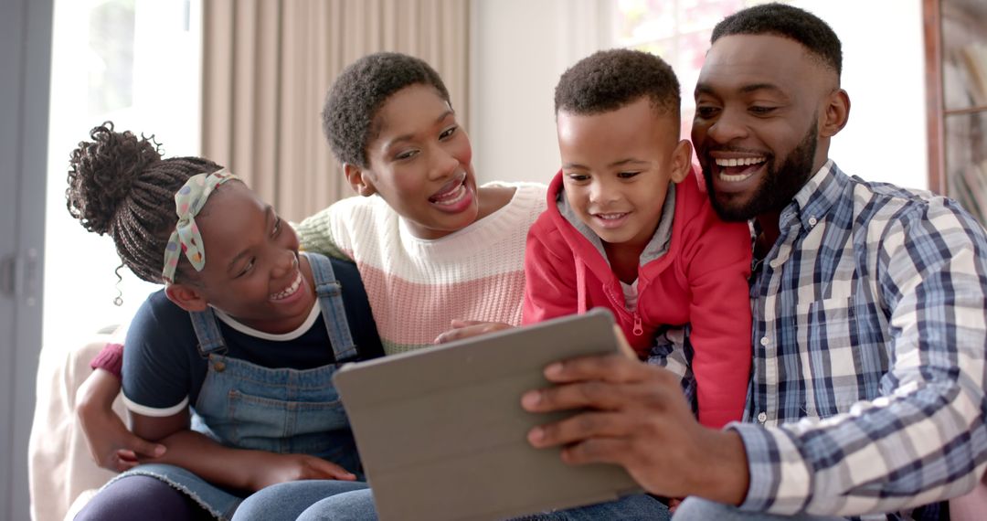 Happy African American Family Laughing and Using Tablet Together - Free Images, Stock Photos and Pictures on Pikwizard.com