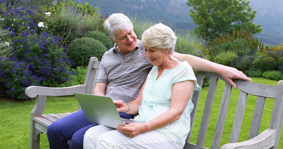 Senior Couple Having a Conversation with Laptop in Tranquil Park