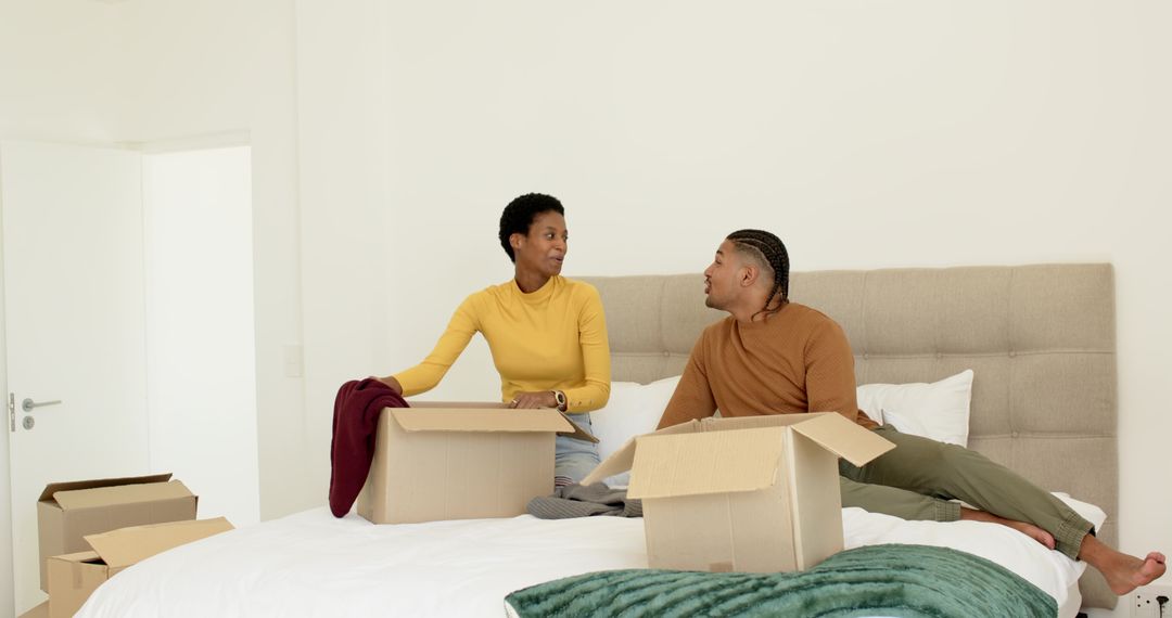 Couple Unpacking on Bed in Cozy Home, Creating Harmonious Space