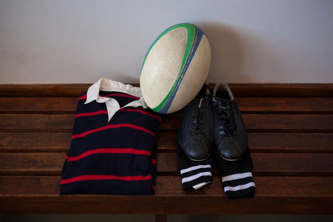 Rugby ball and clothes with shoes on bench in locker room - Free Images, Stock Photos and Pictures on Pikwizard.com