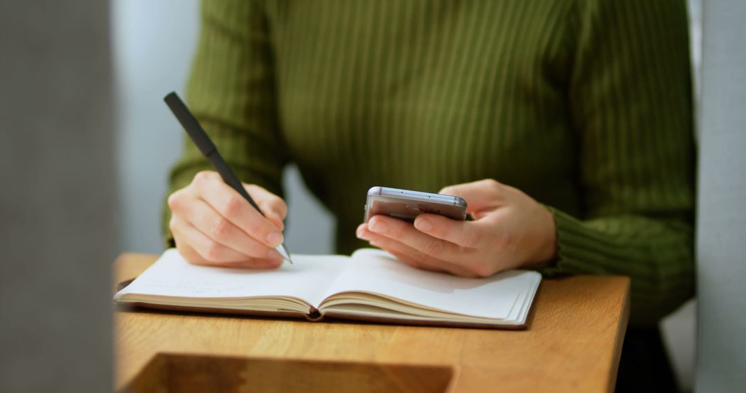 Woman Taking Notes Holding Smartphone While Studying - Free Images, Stock Photos and Pictures on Pikwizard.com