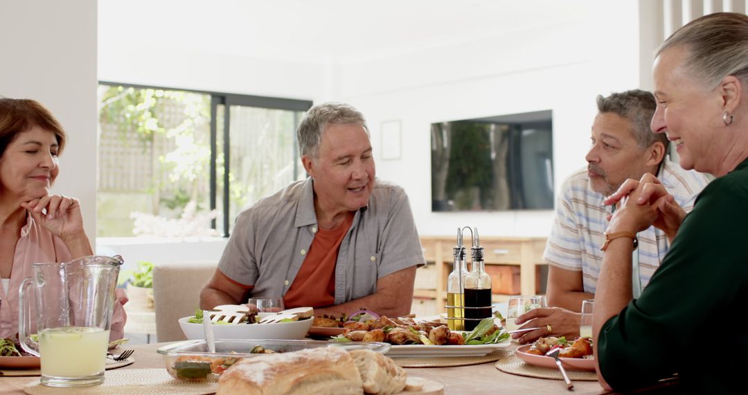 Diverse Friends Enjoying a Meal and Conversation Around Dining Table