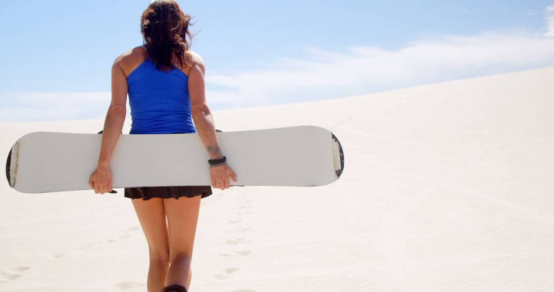 Woman Carrying Snowboard in Desert - Free Images, Stock Photos and Pictures on Pikwizard.com