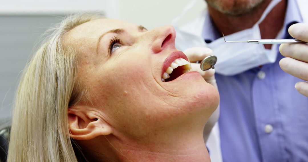 Smiling Woman Receiving Dental Examination by Dentist - Free Images, Stock Photos and Pictures on Pikwizard.com