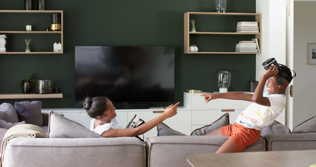 Joyful Siblings Enjoying VR Headset Experience at Home