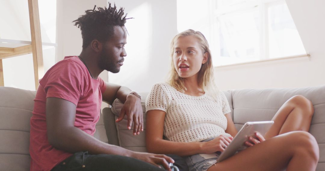 Diverse Friends Discussing Technology Indoors, Relaxing Together