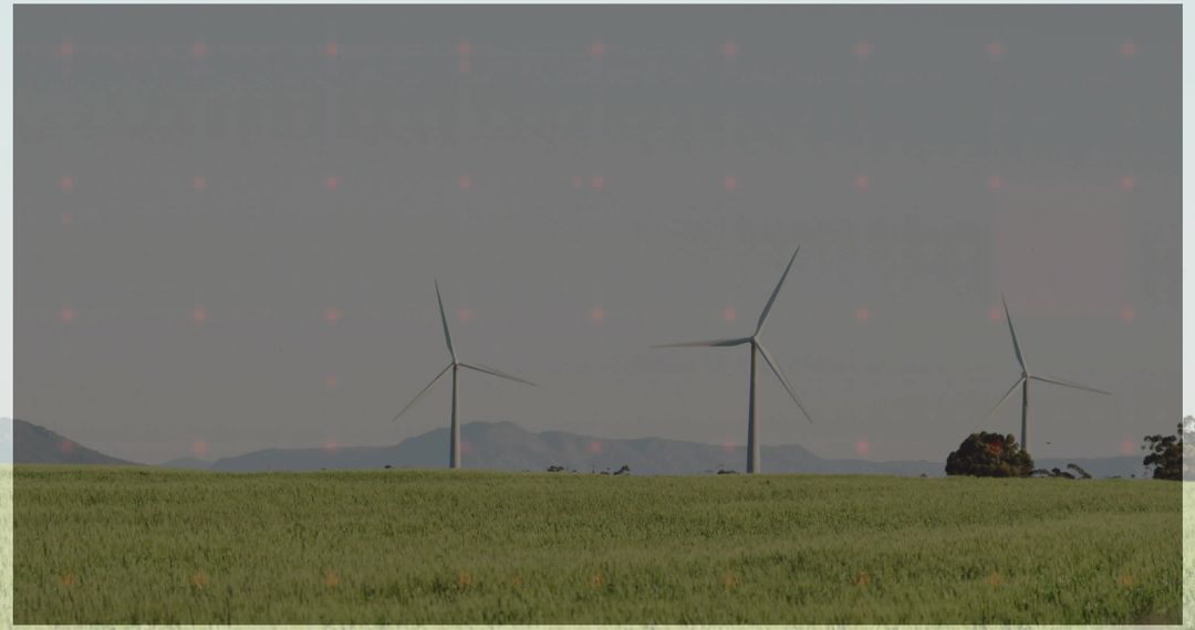 Wind Turbines Generating Clean Energy over Green Crop Field with Rolling Hills Backdrop