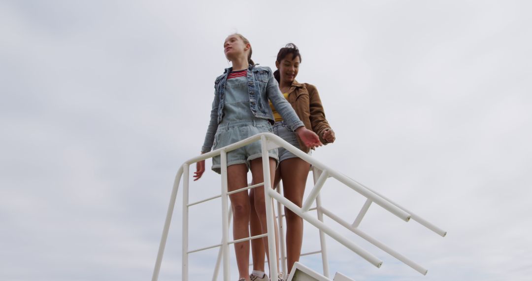 Teen Girls Standing on Lifeguard Tower Holding Hands - Free Images, Stock Photos and Pictures on Pikwizard.com